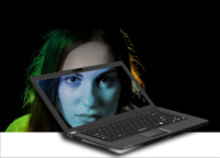 Laptop with person behind it but their face showing on the screen